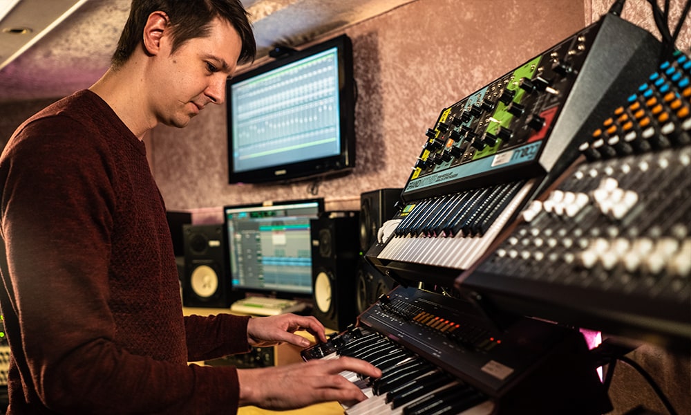 Man playing double-decker synthesizers