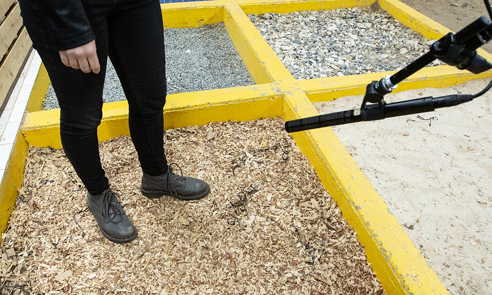 Person stepping on wood chips to produce sound effects