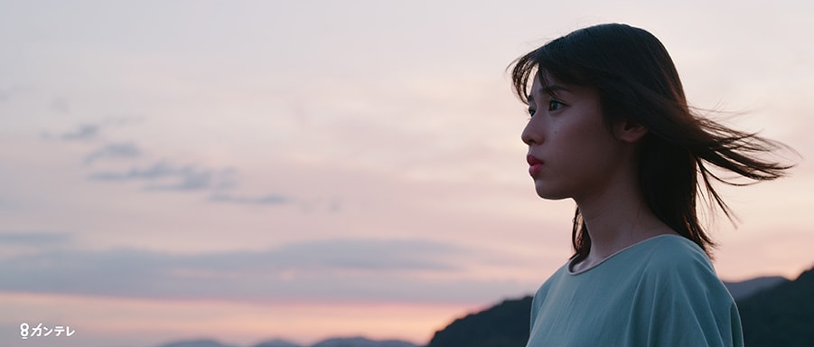 a woman seen in profile against a sunset in a still from three trees