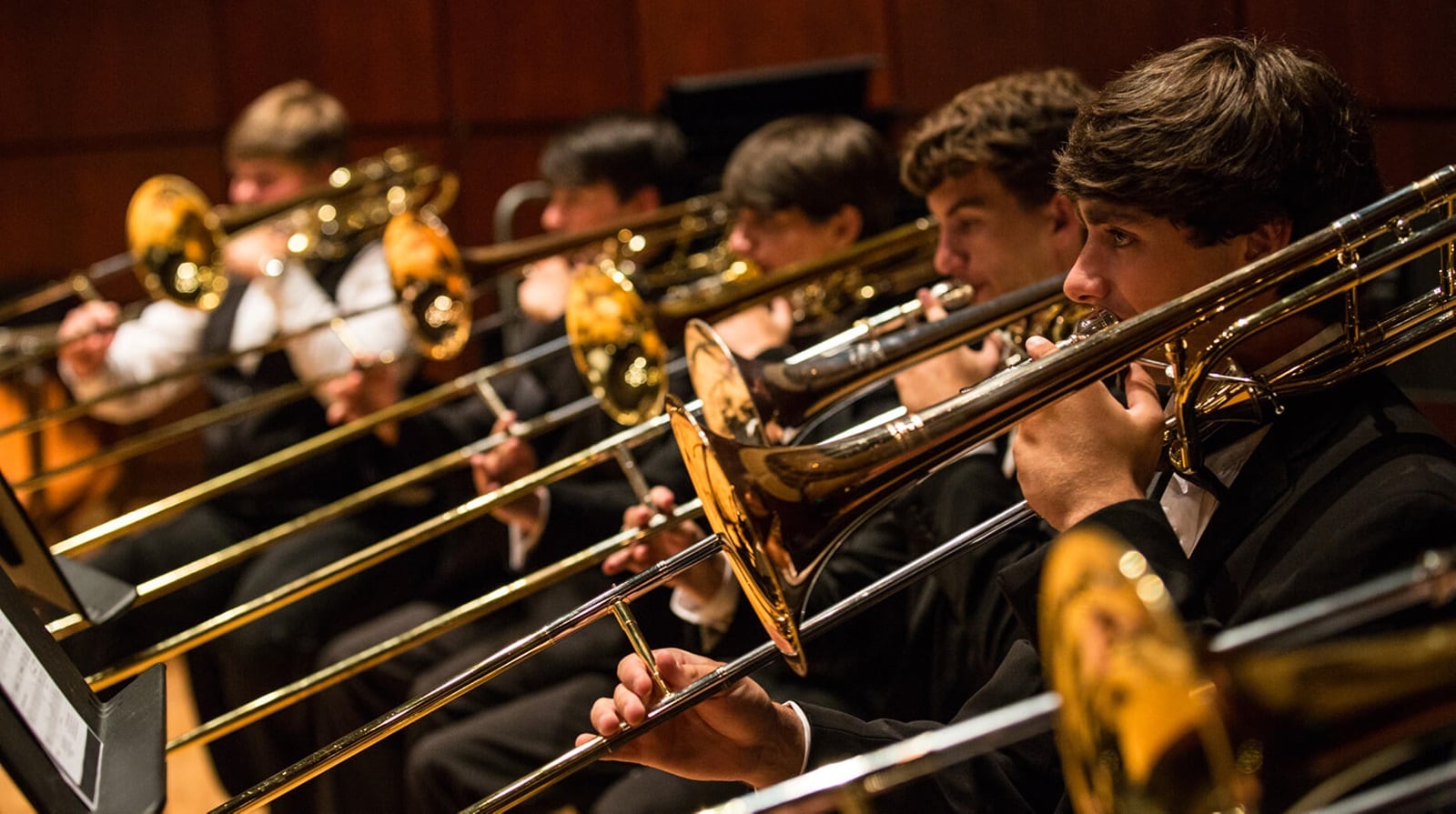 row of trombonists performing in an orchestra